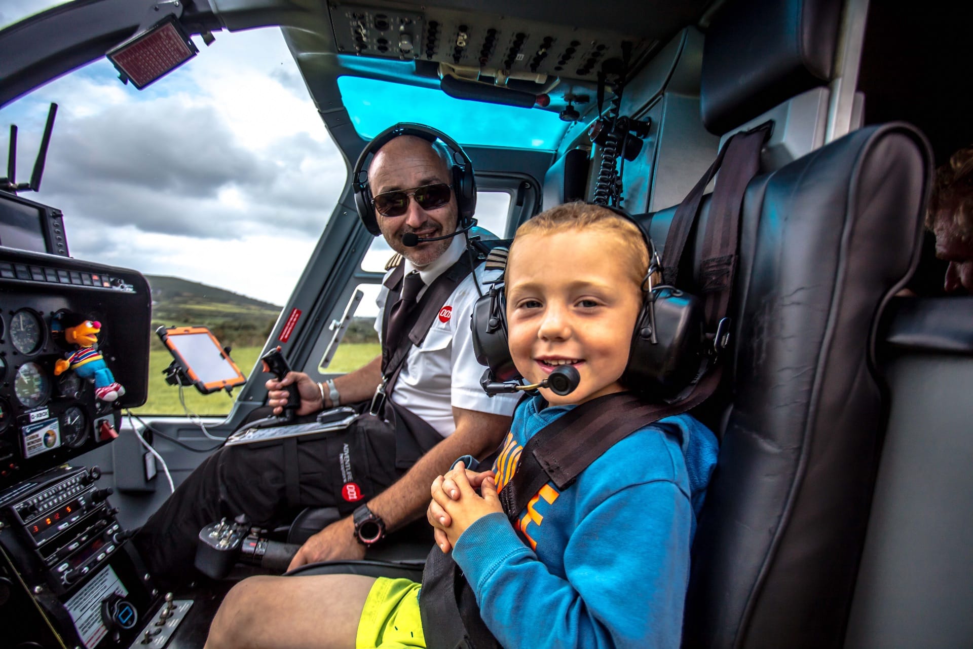 pilot and kid smiling in a helicopter
